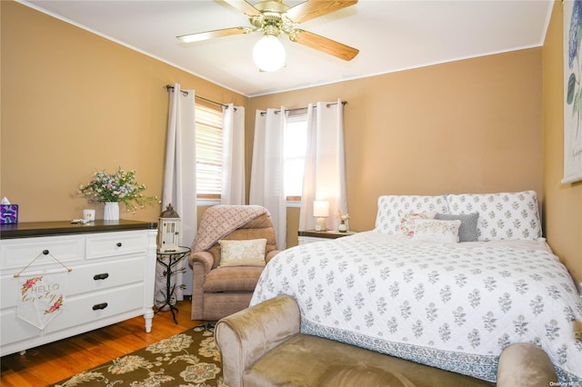 bedroom featuring wood-type flooring, ceiling fan, and crown molding