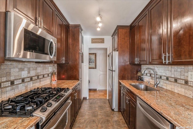 kitchen with decorative backsplash, light stone countertops, sink, and stainless steel appliances