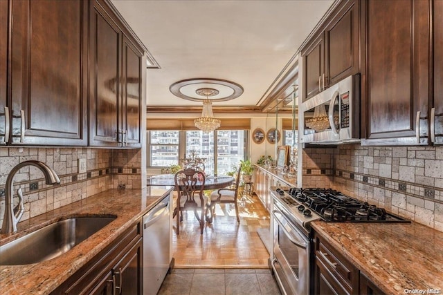 kitchen with appliances with stainless steel finishes, dark hardwood / wood-style flooring, light stone counters, crown molding, and sink