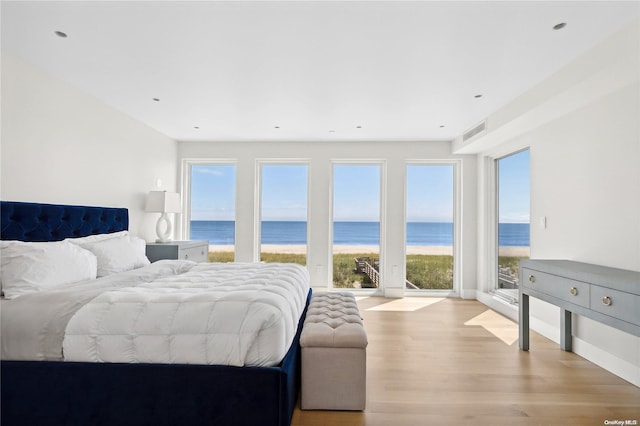 773 Dune Rd, Westhampton Beach, NY 11978 - bedroom with access to exterior, a water view, and light wood-type flooring