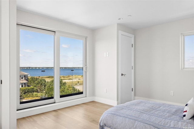 773 Dune Rd, Westhampton Beach, NY 11978 - bedroom with light wood-style flooring and a water view