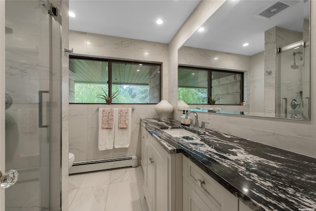 bathroom featuring a healthy amount of sunlight, vanity, walk in shower, and a baseboard heating unit