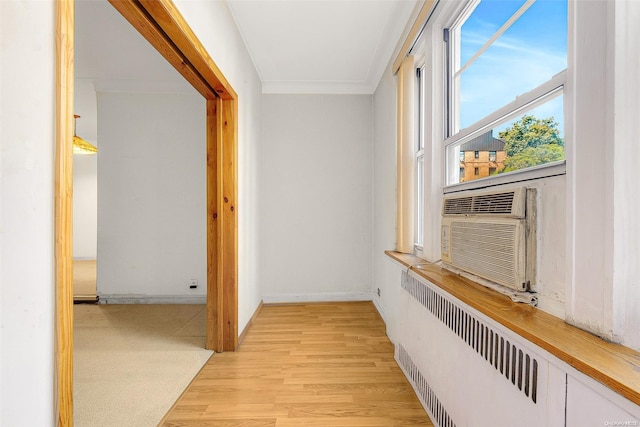 hall featuring radiator heating unit, light hardwood / wood-style floors, cooling unit, and ornamental molding