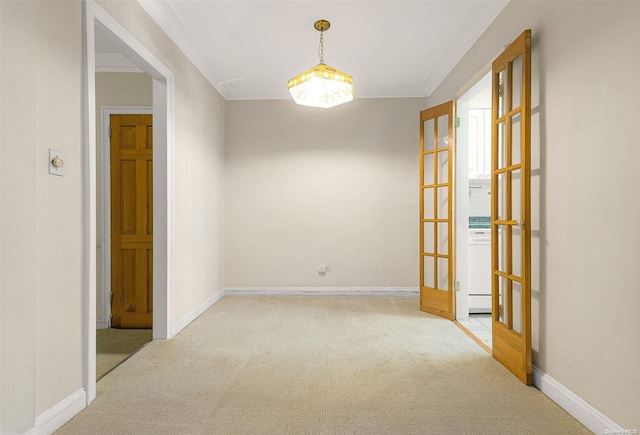 carpeted empty room featuring crown molding and french doors