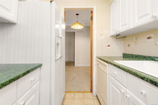 kitchen featuring pendant lighting, white appliances, white cabinets, sink, and light colored carpet