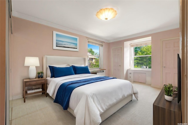 bedroom with ornamental molding and light carpet