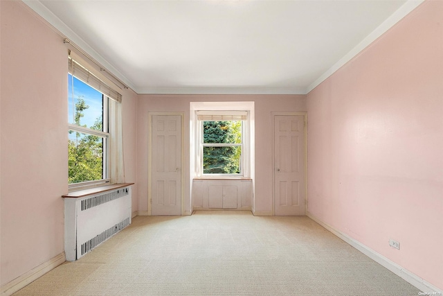 unfurnished living room featuring light carpet, radiator heating unit, and crown molding