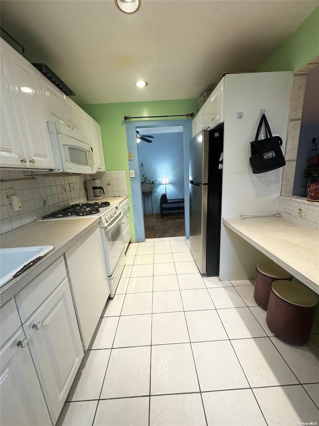 kitchen with ceiling fan, white cabinetry, white appliances, and backsplash