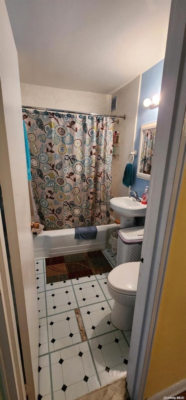 full bathroom with tile patterned flooring, toilet, sink, and shower / tub combo