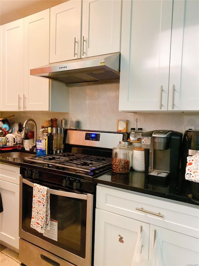 kitchen with white cabinets, decorative backsplash, and stainless steel gas range oven