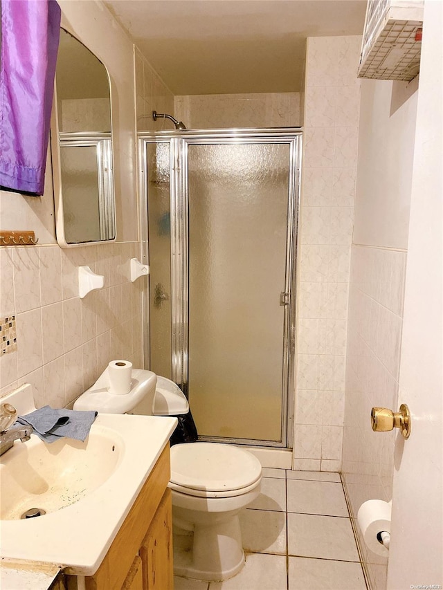 bathroom with vanity, tile patterned flooring, toilet, tile walls, and walk in shower