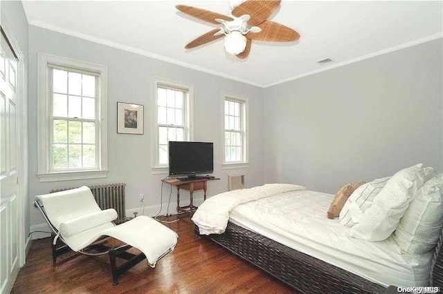 bedroom with radiator heating unit, crown molding, ceiling fan, and dark wood-type flooring