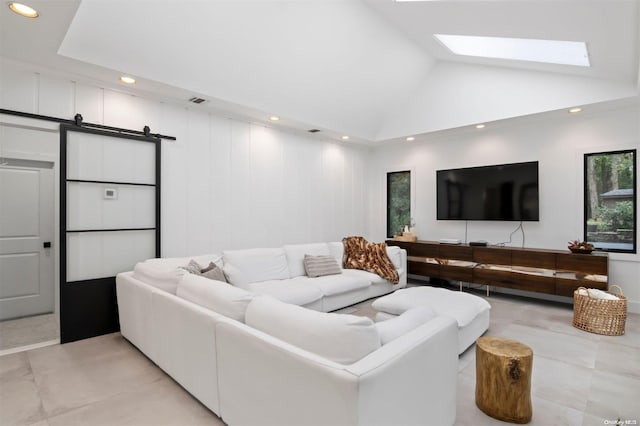 tiled living room featuring a barn door and vaulted ceiling with skylight