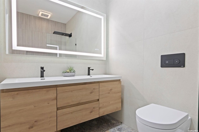 bathroom featuring vanity, toilet, and tile walls