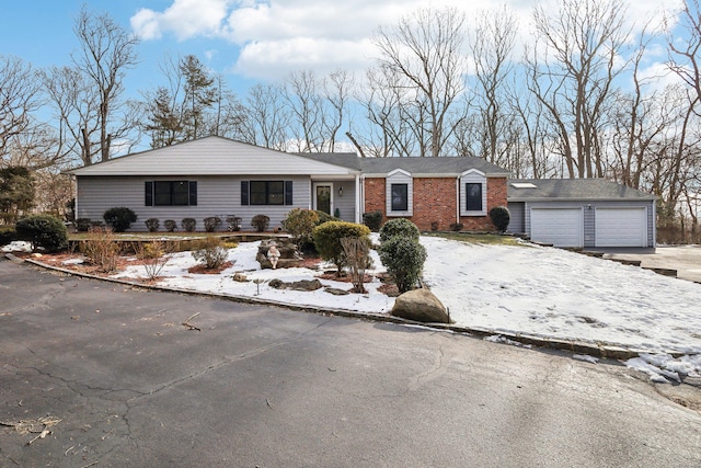 single story home with driveway and brick siding