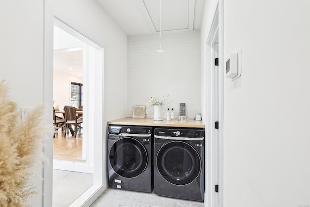 laundry room with laundry area, attic access, and washing machine and clothes dryer