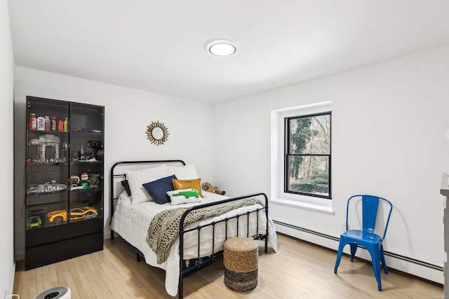 bedroom featuring a baseboard radiator and wood finished floors