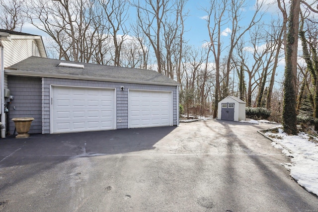 snow covered garage featuring a detached garage