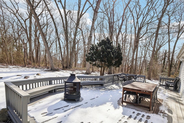 snow covered deck featuring a fire pit