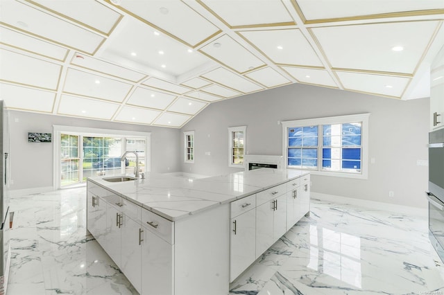 kitchen with a large island with sink, white cabinetry, sink, and plenty of natural light