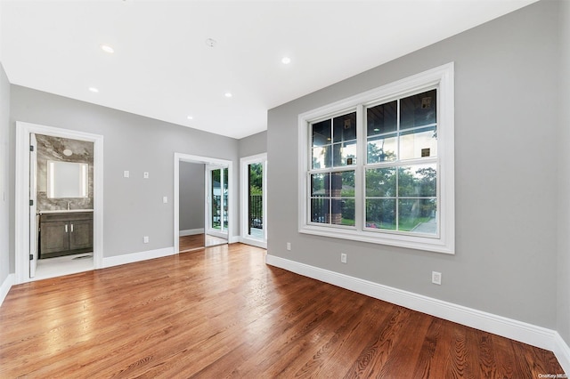 unfurnished living room featuring sink and light hardwood / wood-style floors