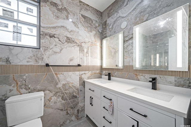 bathroom featuring vanity, toilet, and tile walls