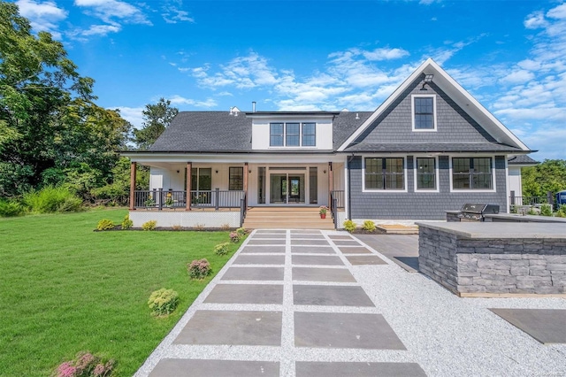 view of front of property with covered porch, exterior kitchen, and a front lawn