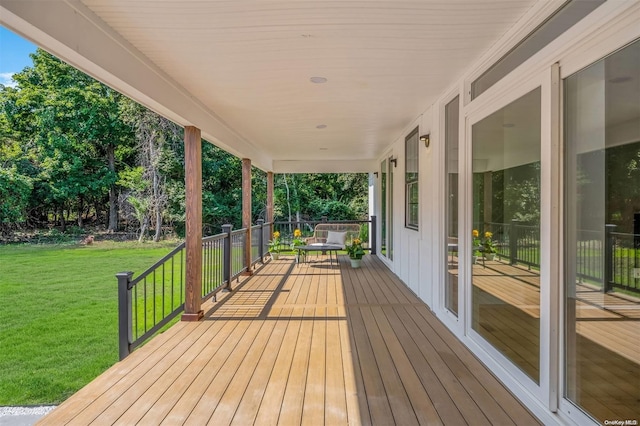 wooden terrace with a yard and covered porch