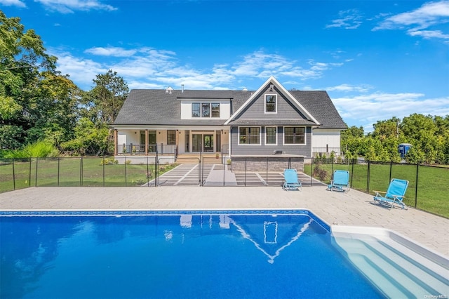 view of pool with a patio and a lawn