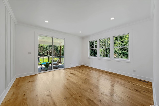 empty room with light hardwood / wood-style floors and crown molding