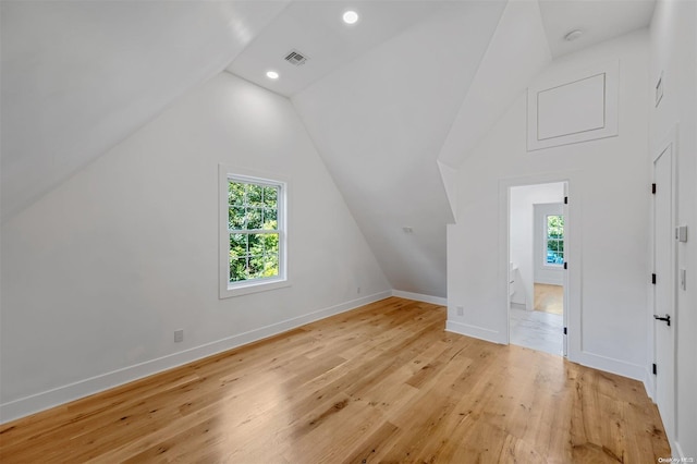 bonus room with vaulted ceiling, light hardwood / wood-style flooring, and plenty of natural light