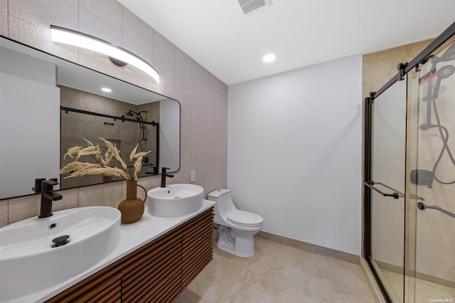 bathroom with vanity, toilet, and a shower with door