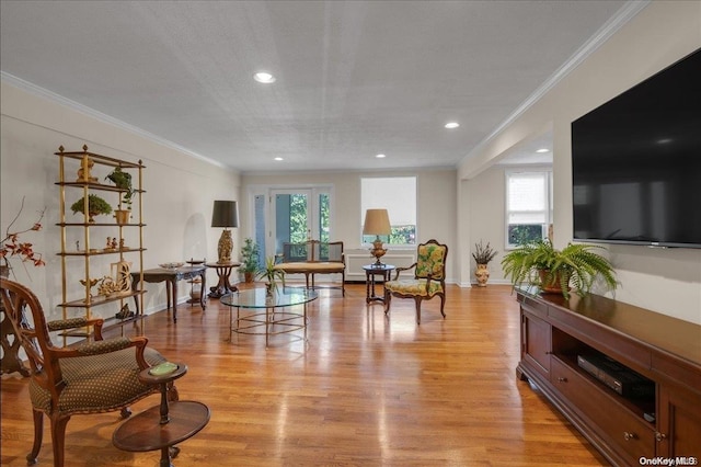 sitting room with a healthy amount of sunlight, light wood-type flooring, and crown molding