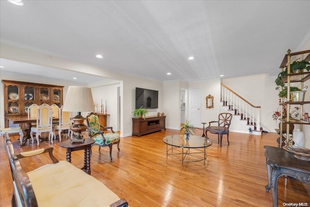 living room featuring light hardwood / wood-style flooring and ornamental molding