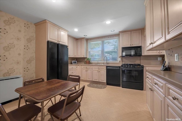 kitchen with sink, light parquet floors, radiator, and black appliances