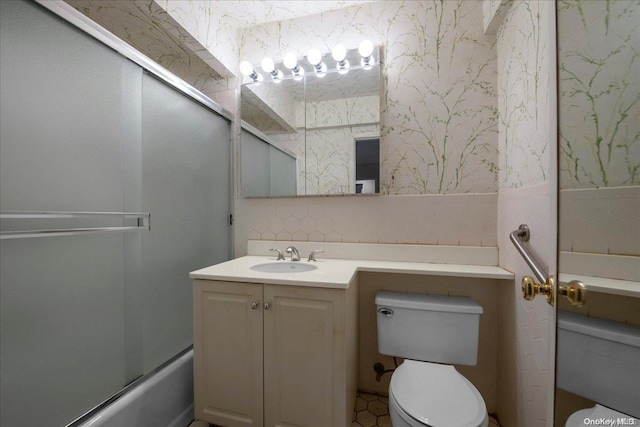 full bathroom featuring vanity, toilet, and shower / bath combination with glass door