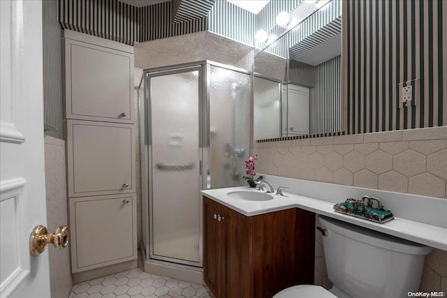 bathroom with tile patterned floors, vanity, toilet, and a shower with shower door