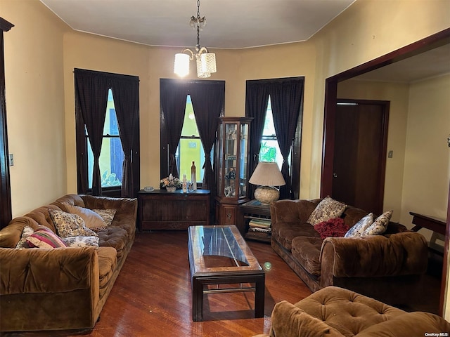 living room with dark hardwood / wood-style floors and an inviting chandelier