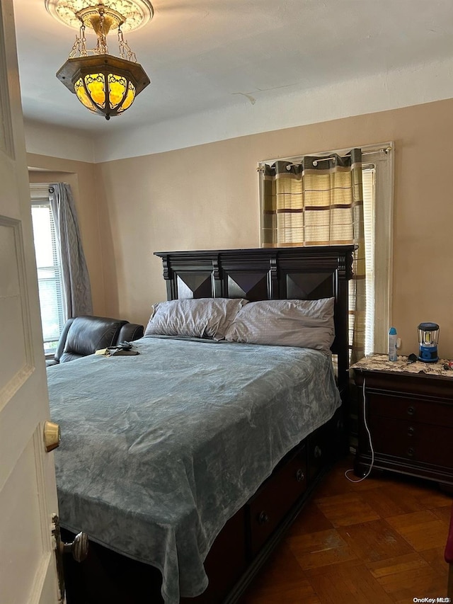 bedroom featuring dark parquet flooring