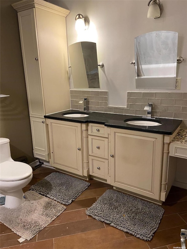 bathroom featuring hardwood / wood-style floors, decorative backsplash, toilet, and vanity