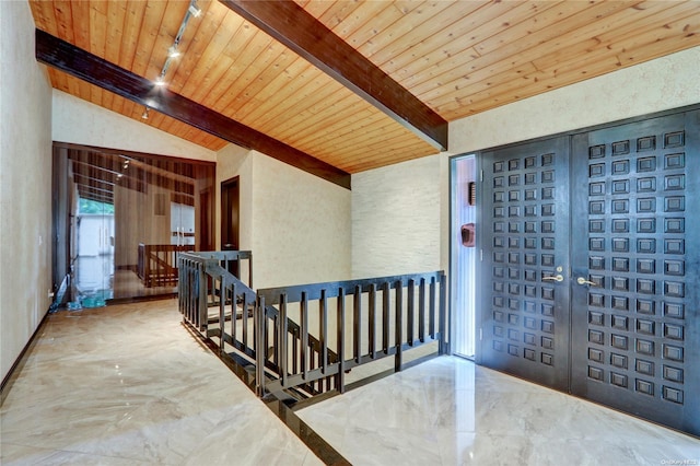 foyer entrance with lofted ceiling with beams, wood ceiling, and rail lighting