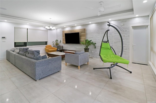 living room with light tile patterned flooring and ceiling fan with notable chandelier