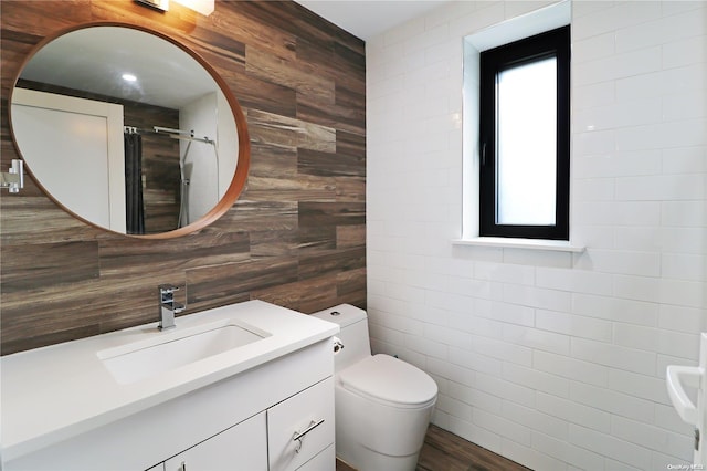 bathroom featuring walk in shower, vanity, hardwood / wood-style flooring, tile walls, and wood walls