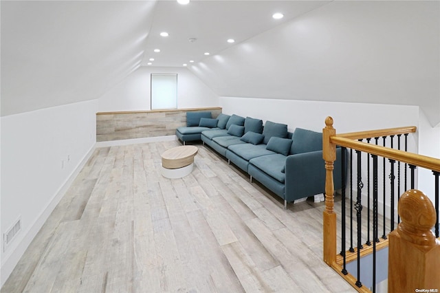 living room with light hardwood / wood-style floors and vaulted ceiling