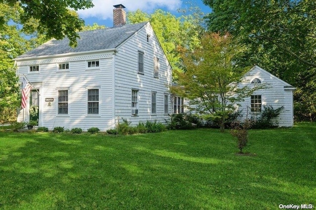 view of side of home featuring cooling unit and a lawn