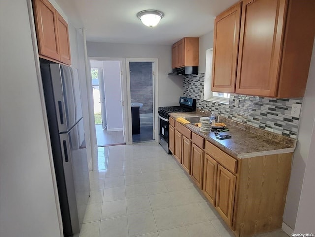 kitchen featuring backsplash, light tile patterned flooring, and stainless steel appliances