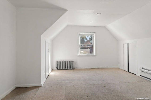 bonus room featuring radiator, light carpet, and lofted ceiling