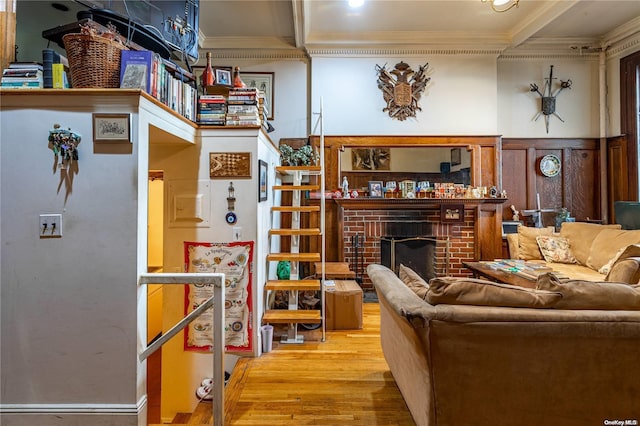 living room with a fireplace, hardwood / wood-style flooring, and crown molding