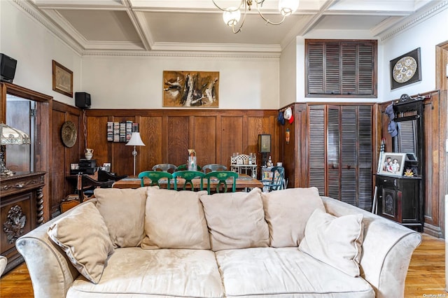 living room with a notable chandelier, wood-type flooring, crown molding, and coffered ceiling