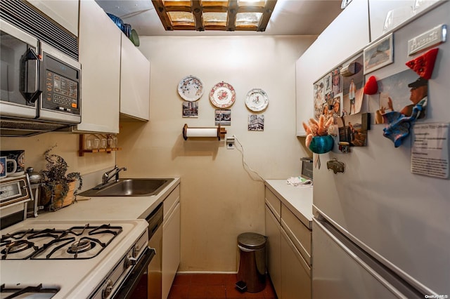 kitchen with tile patterned floors, white cabinetry, sink, and appliances with stainless steel finishes